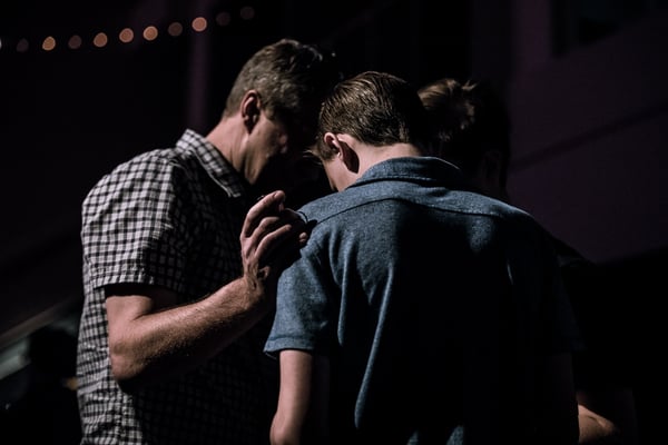 youth pastor praying for student