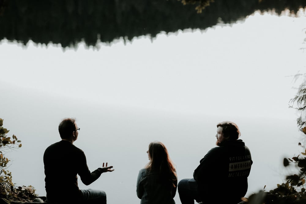 YWAMers talking together beside a lake 